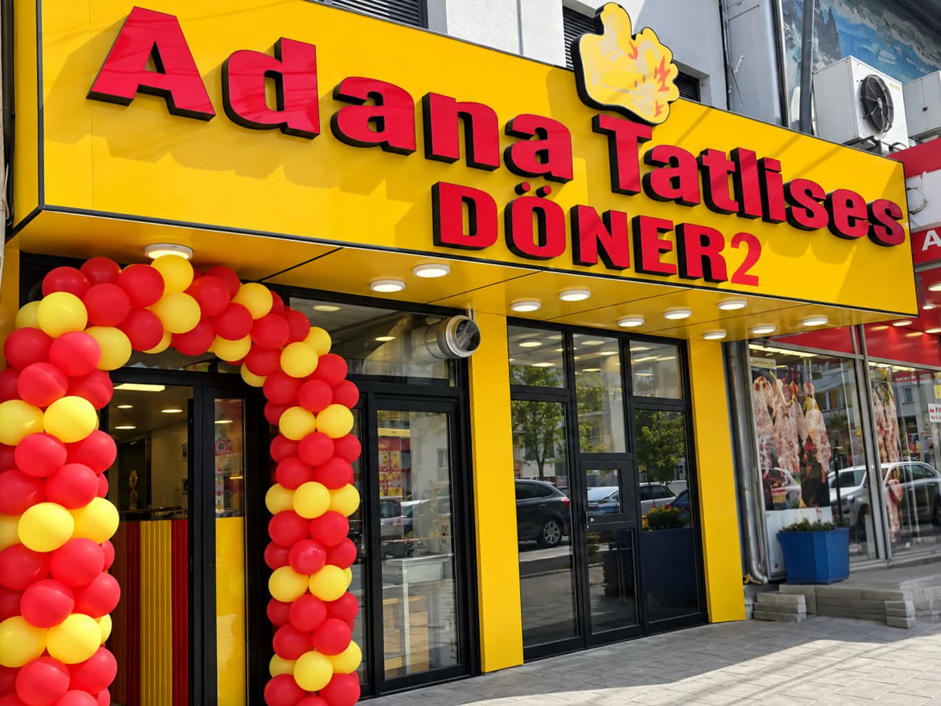 Adana Tatlıses Döner 2’nin sarı cepheli, kırmızı ve sarı balonlarla süslenmiş Prizren’deki girişi